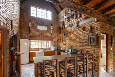 a kitchen with a table and a brick wall at Mapula in Marloth Park