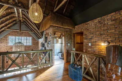 a room with a brick wall and a bathroom with a toilet at Mapula in Marloth Park