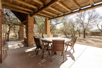 a wooden table and chairs on a patio at Mapula in Marloth Park