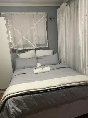 a bed with two towels on it with a window at Holiday apartment in Kempton Park