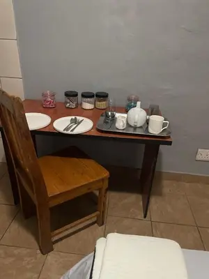 a table with plates and utensils on it at Holiday apartment in Kempton Park
