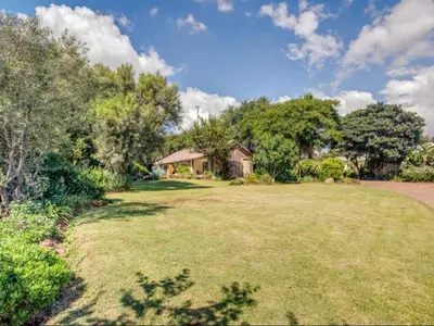 a large yard with a house and trees at Jacobs Well Guest House in Centurion