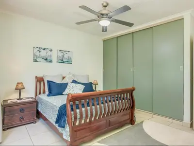a bedroom with a bed and a ceiling fan at Jacobs Well Guest House in Centurion