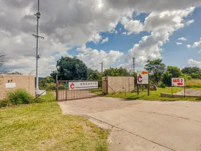 a gate to a parking lot with a gas station at Jacobs Well Guest House in Centurion