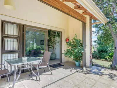 a patio with a table and chairs on a patio at Jacobs Well Guest House in Centurion
