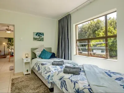 a bedroom with a bed and a large window at Jacobs Well Guest House in Centurion