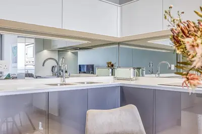 a kitchen with white counters and sinks and a chair at Luxurious living Waterfall in Midrand