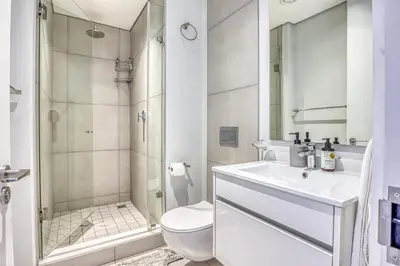 a bathroom with a shower and a toilet and a sink at Luxurious living Waterfall in Midrand