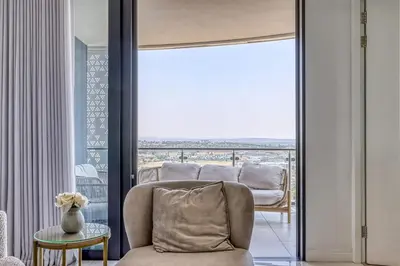 a living room with a couch and a large window at Luxurious living Waterfall in Midrand
