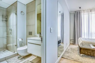 a bathroom with a toilet sink and a shower at Luxurious living Waterfall in Midrand