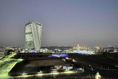 a tall building in a city at night at Explore Ellipse - Peacock Room in Midrand