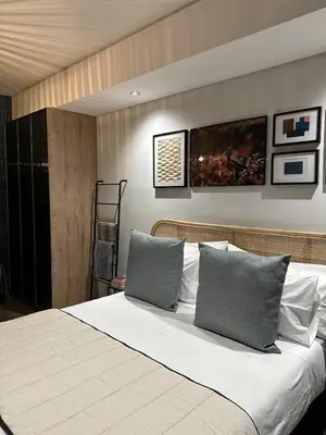 a bedroom with a large bed with two pillows at Explore Ellipse - Peacock Room in Midrand
