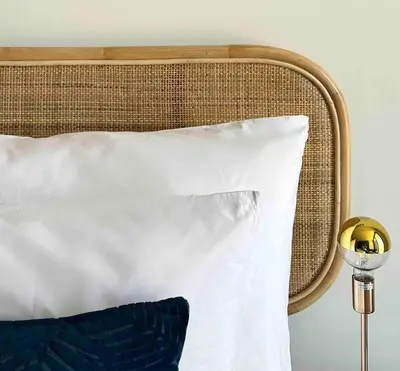 a bed with a white pillow and a yellow lamp at Explore Ellipse - Peacock Room in Midrand