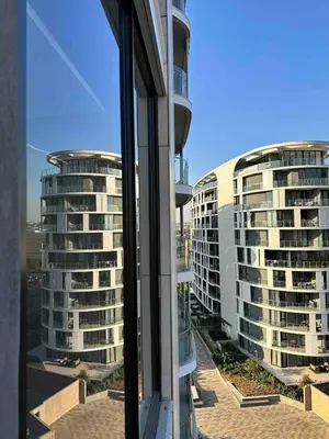 a view of two tall buildings from a window at Explore Ellipse - Peacock Room in Midrand