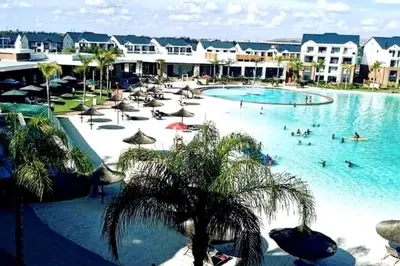 a large swimming pool with people in a resort at Serenity Stay at The Blyde River Walk Estate in Pretoria