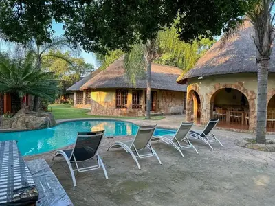 a group of chairs sitting next to a pool at 63OnNyala Function lodge and spa venue in Pretoria