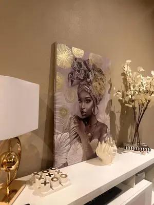 a painting of a black woman sitting on a shelf at Haven on Glen in Johannesburg