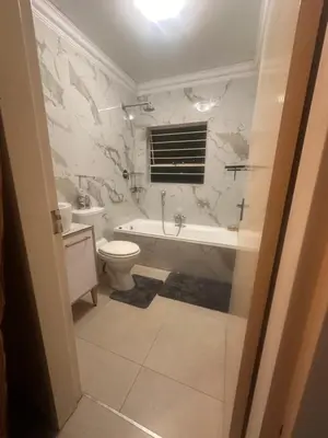 a bathroom with a toilet and a tub and a sink at Haven on Glen in Johannesburg