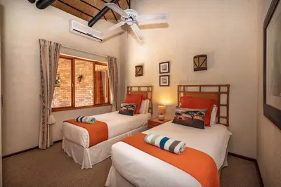 a bedroom with two beds and a window at Kruger Park Lodge Unit No 303 in Hazyview