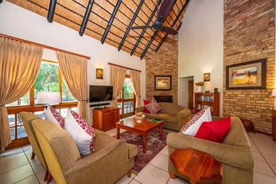a living room with two couches and a tv at Kruger Park Lodge Unit No 303 in Hazyview