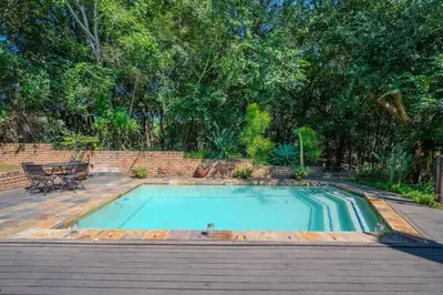 a swimming pool in a backyard with a table and chairs at Kruger Park Lodge Unit No 303 in Hazyview
