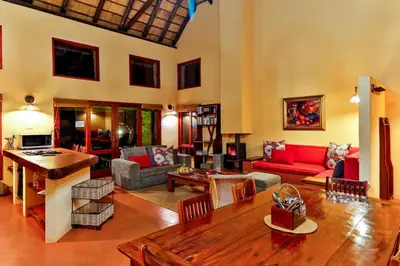a living room with a red couch and a table at Verlorenkloof Estate in Wagenbietjieshoek