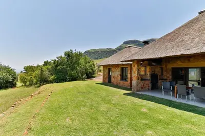 a building with a table and chairs outside of it at Verlorenkloof Estate in Wagenbietjieshoek