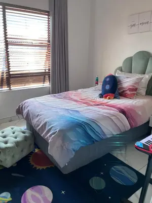 a bedroom with a bed with a stuffed animal on it at Cosy 3 bedroom apartment In Pretoria East in Pretoria