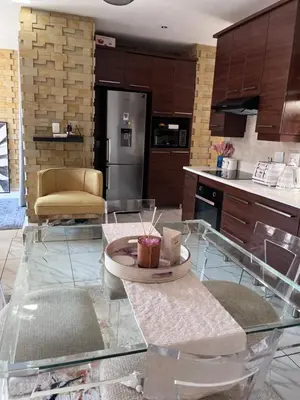 a kitchen with a glass table in a kitchen at Cosy 3 bedroom apartment In Pretoria East in Pretoria