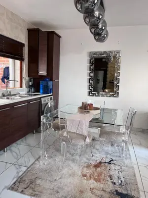 a kitchen with a glass table and some chairs at Cosy 3 bedroom apartment In Pretoria East in Pretoria