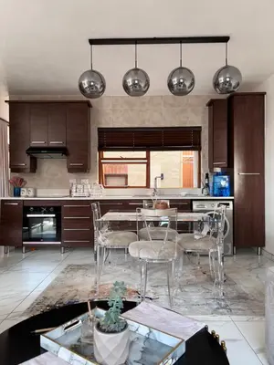 a kitchen with a table and chairs in it at 3 bedroom holiday apartment in Pretoria East in Pretoria