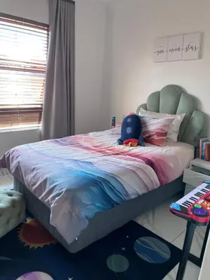 a bedroom with a bed with a stuffed animal on it at 3 bedroom holiday apartment in Pretoria East in Pretoria
