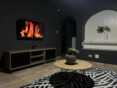 a living room with a table and a fire fireplace at 13 Orion Aparment in Polokwane