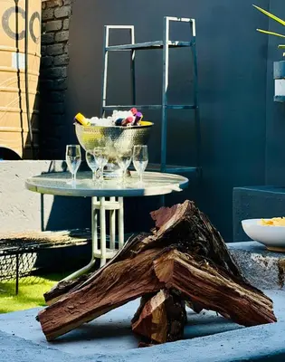 a table with glasses and a bowl on top of a wooden stump at 13 Orion Aparment in Polokwane