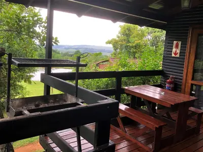 a porch with a table and a grill and a picnic table at Zur Alten Mine in Graskop