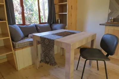 a table and a chair in a room with a couch at Zur Alten Mine in Graskop