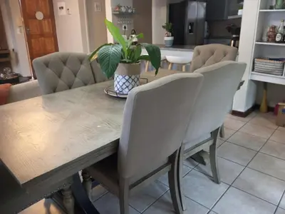 a dining room table with chairs and a potted plant at Urban Nest in Polokwane