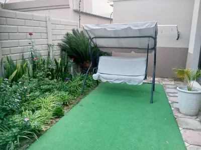 a chair sitting on a green carpet in a garden at Urban Nest in Polokwane
