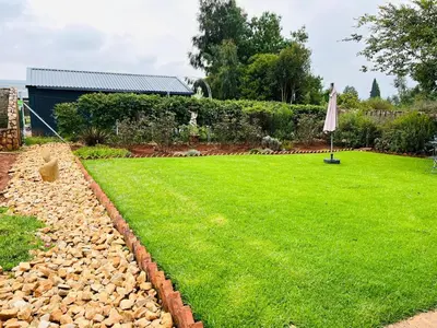 a lawn with an umbrella in a yard at Clarkys Bucketlist Dullstroom in Dullstroom