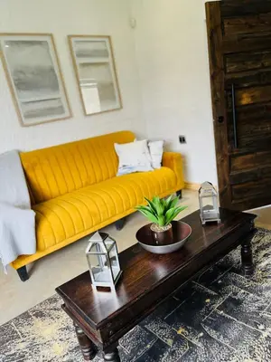 a living room with a yellow couch and a coffee table at Clarkys Bucketlist Dullstroom in Dullstroom
