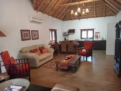 a living room with a couch and a table at Iphupho Bush Lodge, Ba-Phalaborwa Golf Estate in Phalaborwa