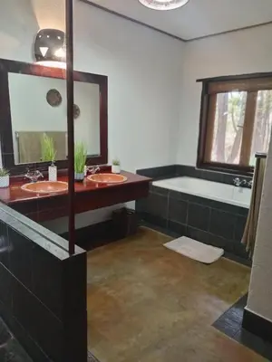 a bathroom with two sinks and a bath tub at Iphupho Bush Lodge, Ba-Phalaborwa Golf Estate in Phalaborwa