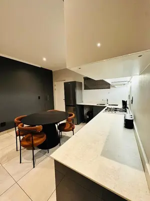 a large kitchen with a table and some chairs at Next to Brooklyn Mall Cosy stay in Pretoria