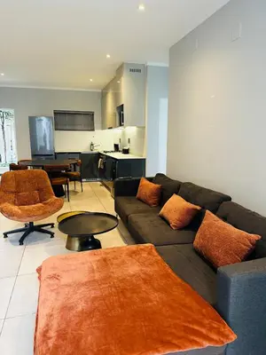 a living room with a couch and a table at Next to Brooklyn Mall Cosy stay in Pretoria