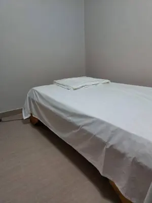 a white bed sitting in a corner of a room at Un-Furnished Rooms Contractors Accomodation at 66 Pongola Street, MIDDELBURG, Mpumalanga in Middelburg