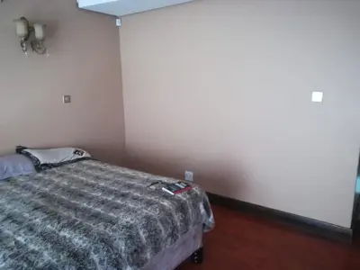 a bedroom with a bed in the corner of a room at Un-Furnished Rooms Contractors Accomodation at 66 Pongola Street, MIDDELBURG, Mpumalanga in Middelburg