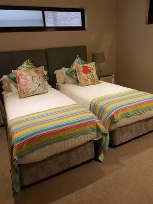 a bedroom with two beds with colorful blankets and pillows at Un-Furnished Rooms Contractors Accomodation at 66 Pongola Street, MIDDELBURG, Mpumalanga in Middelburg