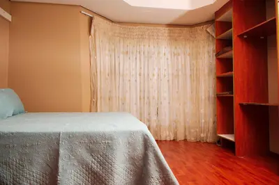 a bedroom with a bed with a curtain and a book shelf at Un-Furnished Rooms Contractors Accomodation at 66 Pongola Street, MIDDELBURG, Mpumalanga in Middelburg