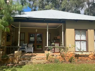 a small house with a porch and a patio at Legodimo Cottage in Dullstroom