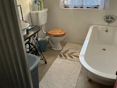 a bathroom with a toilet and a tub and a sink at Legodimo Cottage in Dullstroom